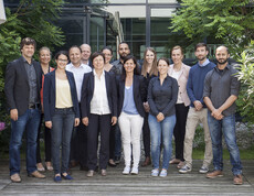 Ein Gruppenfoto von vielen Arbeitern. Alle sind nobel gekleidet.