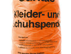 Der orange Caritas Kleidersack. Er hat Platz für zirka 8,5 Kilogramm Kleidung.